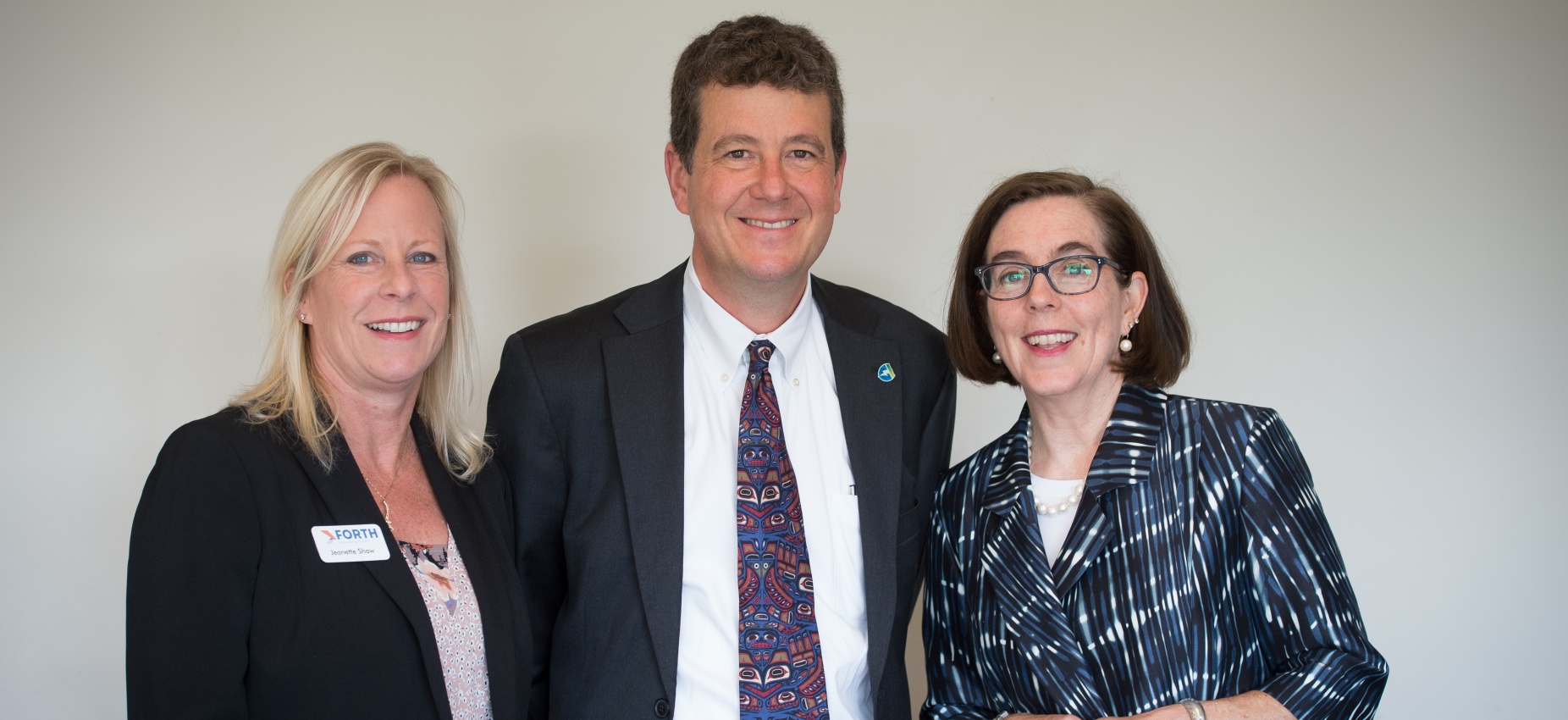 Oregon Governor Kate Brown smiling with Jeff Allen and Jeanette Shaw of Forth
