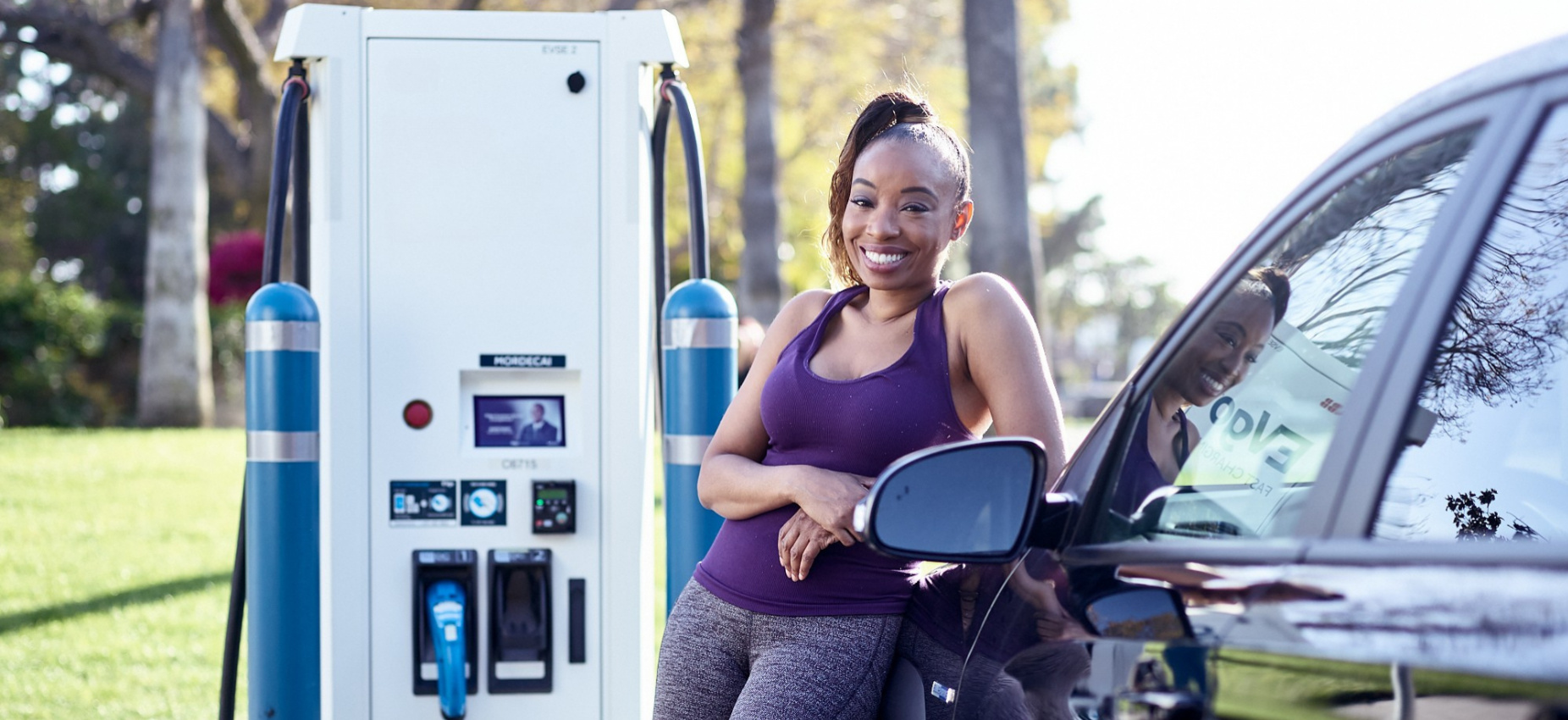 Woman of color charging EV at a public charger