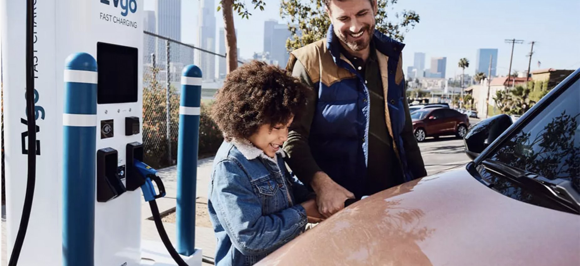 Father and son smiling using a public charger